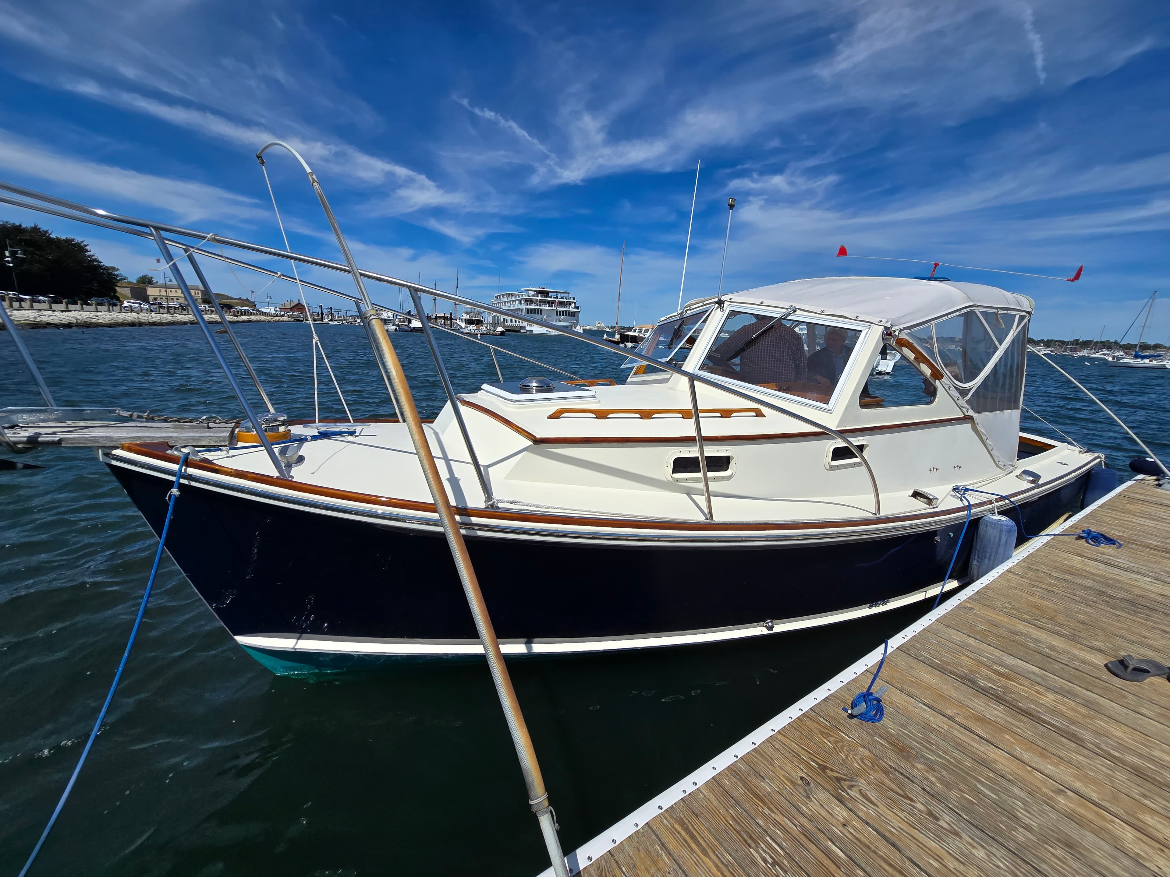A 1985 Dyer 29 on her mooring after a winter refit, Newport waterfront behind her
